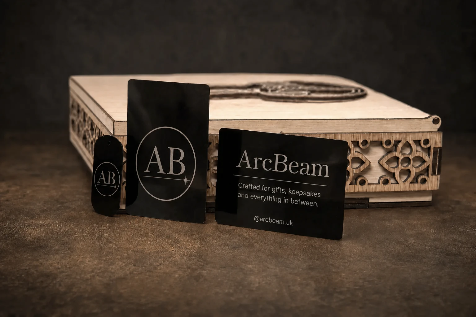Laser-cut wooden presentation box with ArcBeam-engraved black metal cards and a matching tag